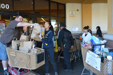      Nov. 23, 2013- Standing outside the Safeway entrance doors, volunteers collect food bags and items from the shoppers. Volunteers only collected items for one day, but people had the option of putting their donated food in bins located inside the store. “I decided to come here because I think it is important to help out, so people become aware of this organization” freshman Jessica Au said. 